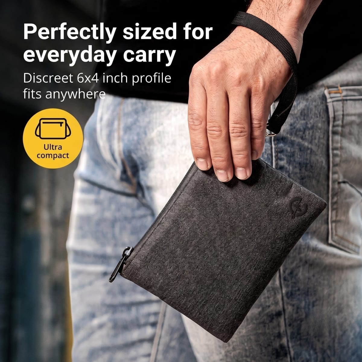 Person holding an Epulse smell proof bag by its wrist strap, showing the compact 6 by 4 inch profile against denim clothing